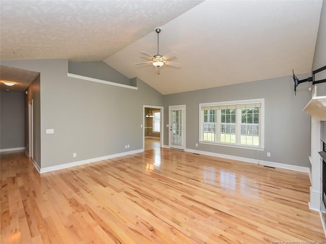 unfurnished living room featuring a textured ceiling, vaulted ceiling, light hardwood / wood-style flooring, and ceiling fan