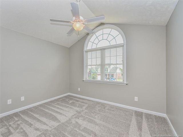 carpeted empty room with ceiling fan and lofted ceiling