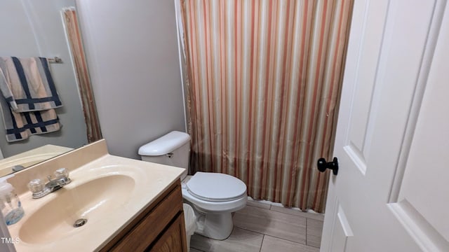 bathroom with tile patterned flooring, vanity, and toilet