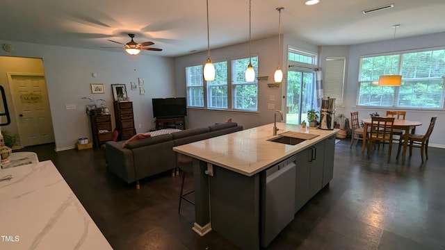 kitchen with ceiling fan, sink, dishwasher, hanging light fixtures, and an island with sink