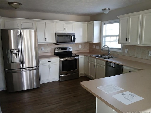 kitchen featuring white cabinetry, sink, stainless steel appliances, tasteful backsplash, and dark hardwood / wood-style flooring