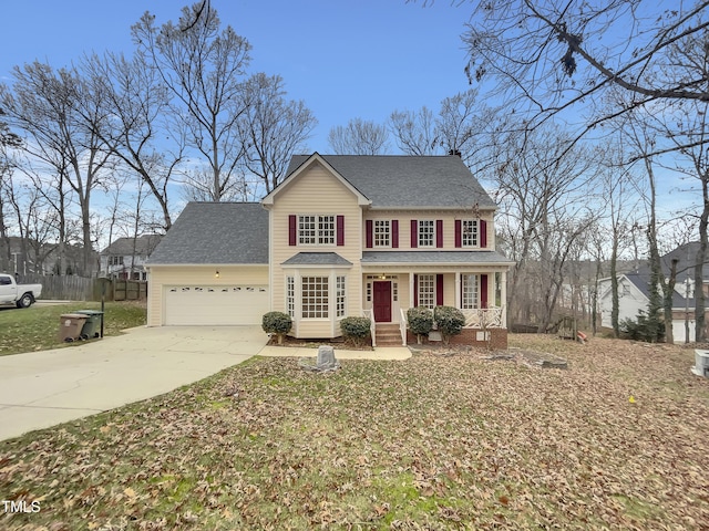 colonial inspired home featuring covered porch and a garage