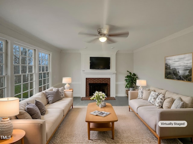 living room featuring ceiling fan, crown molding, and a brick fireplace