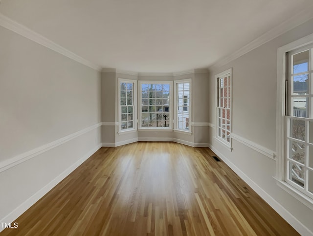 empty room featuring light hardwood / wood-style floors and ornamental molding