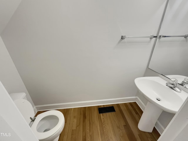 bathroom with hardwood / wood-style floors and toilet