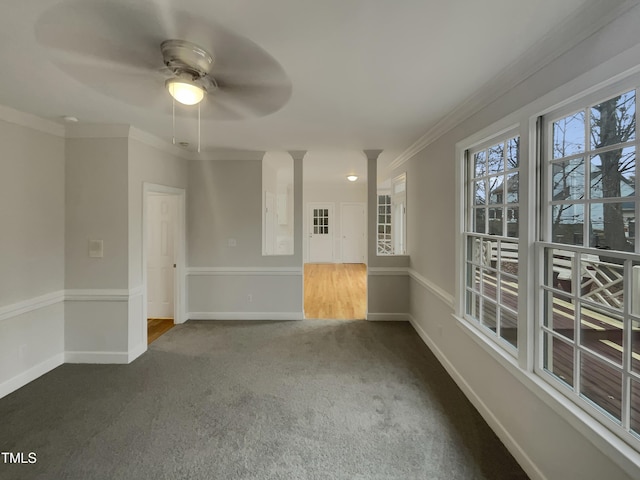 empty room featuring carpet, ceiling fan, ornate columns, and crown molding