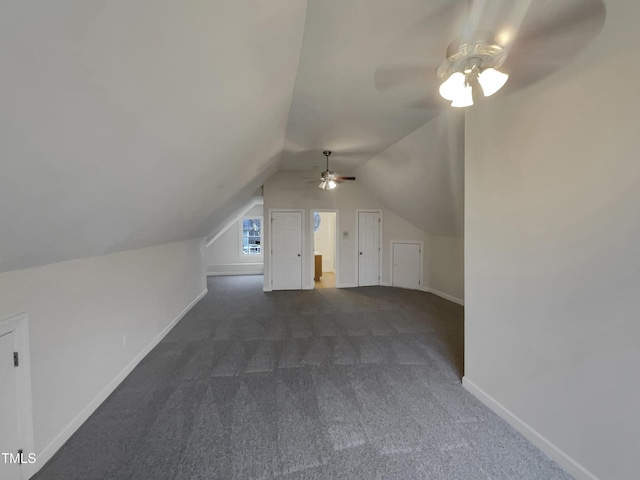 bonus room with ceiling fan, dark carpet, and lofted ceiling