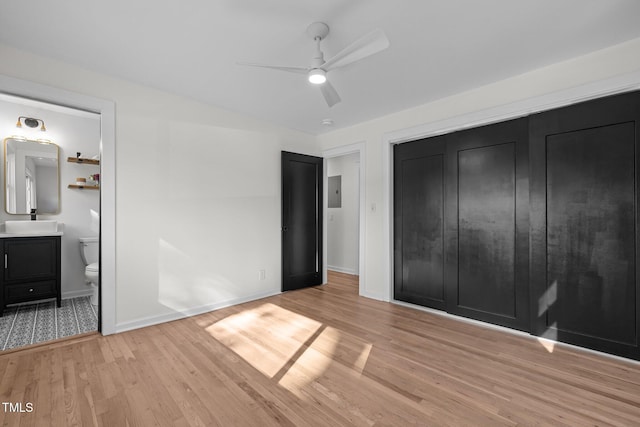 unfurnished bedroom with ensuite bath, ceiling fan, and light hardwood / wood-style flooring