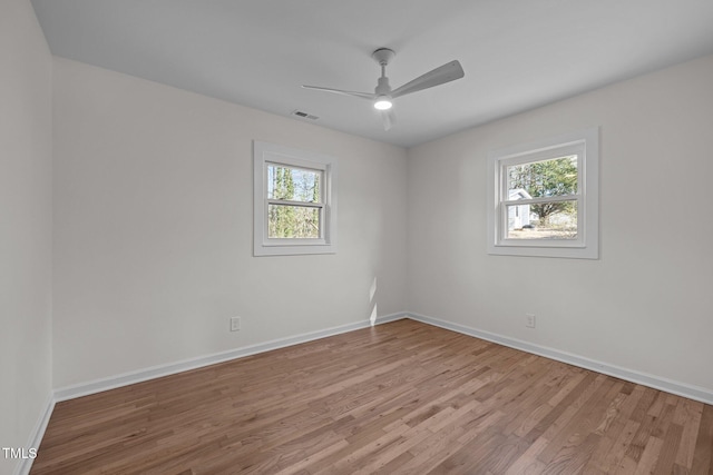 spare room featuring ceiling fan, a healthy amount of sunlight, and light wood-type flooring