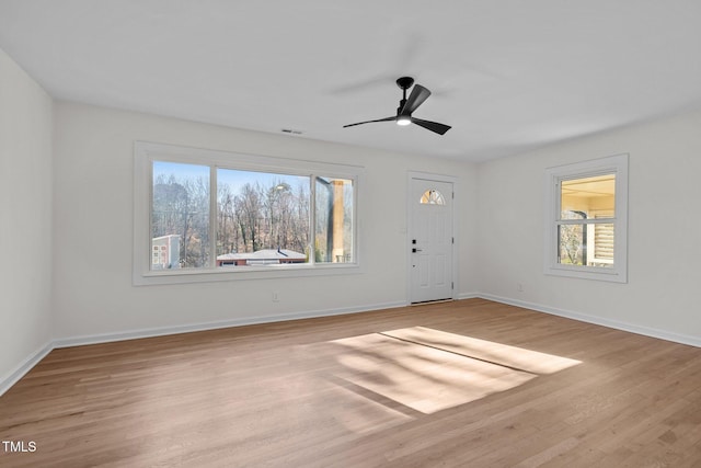 empty room with ceiling fan and light hardwood / wood-style flooring