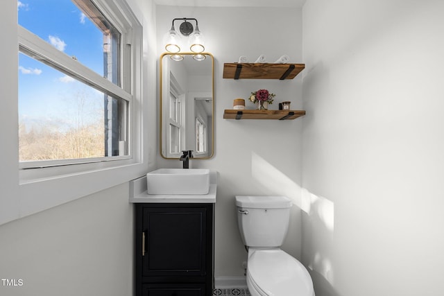 bathroom with vanity, a healthy amount of sunlight, and toilet