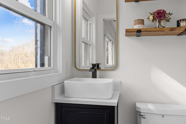 bathroom featuring vanity, a healthy amount of sunlight, and toilet