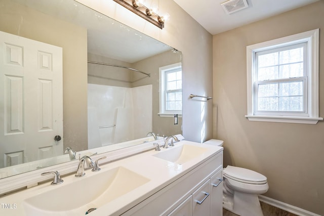 bathroom featuring vanity, a healthy amount of sunlight, and toilet