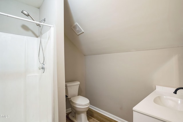 bathroom featuring wood-type flooring, vanity, toilet, and walk in shower