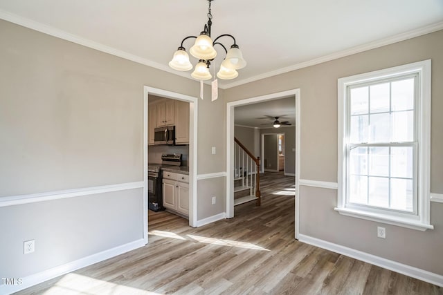 unfurnished dining area featuring light hardwood / wood-style floors, ceiling fan with notable chandelier, and ornamental molding