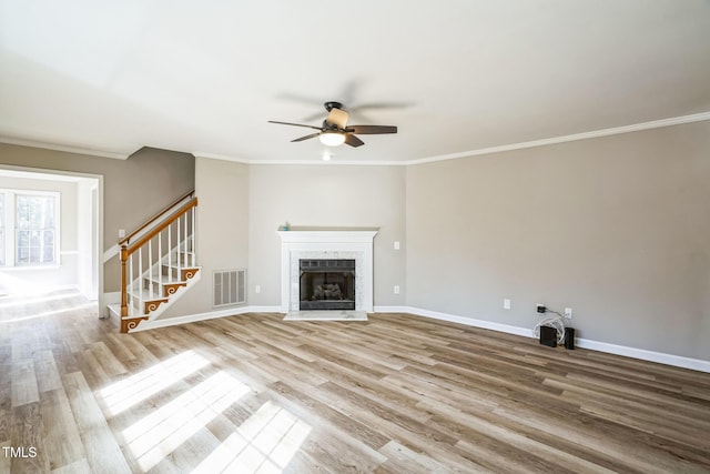 unfurnished living room featuring hardwood / wood-style flooring, ceiling fan, and ornamental molding