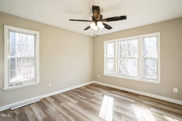 empty room with ceiling fan and light hardwood / wood-style flooring