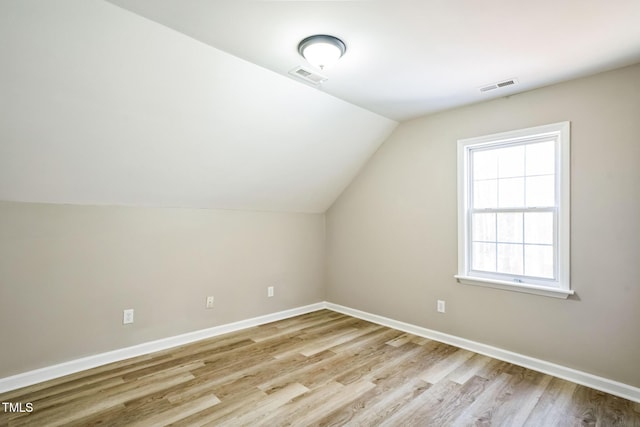 bonus room with light hardwood / wood-style floors and lofted ceiling