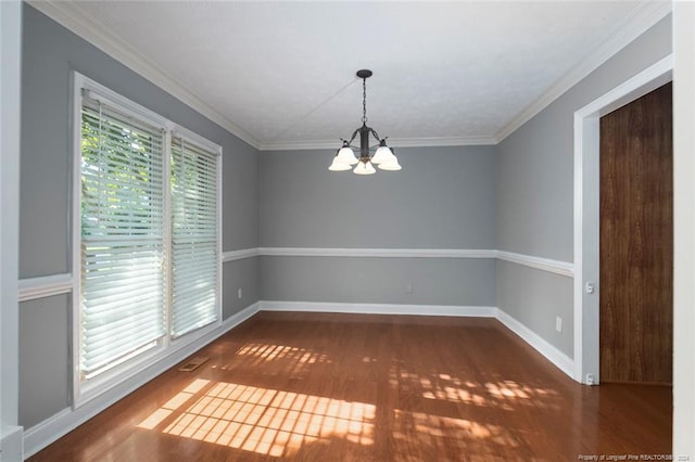 spare room with dark hardwood / wood-style flooring, crown molding, and a notable chandelier