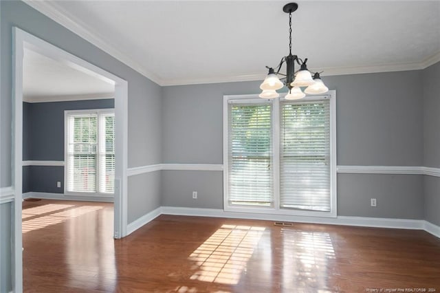 empty room with dark hardwood / wood-style flooring, crown molding, and an inviting chandelier