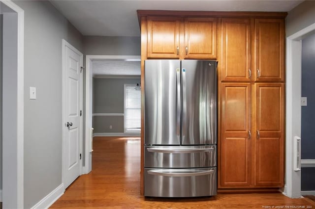 kitchen featuring stainless steel fridge and light hardwood / wood-style floors