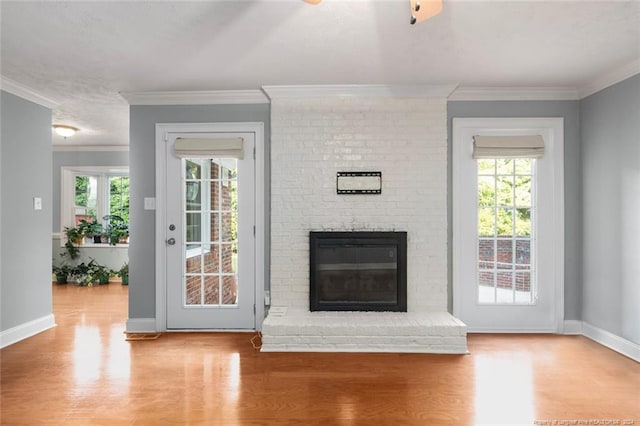 unfurnished living room featuring a brick fireplace, light hardwood / wood-style flooring, and ornamental molding