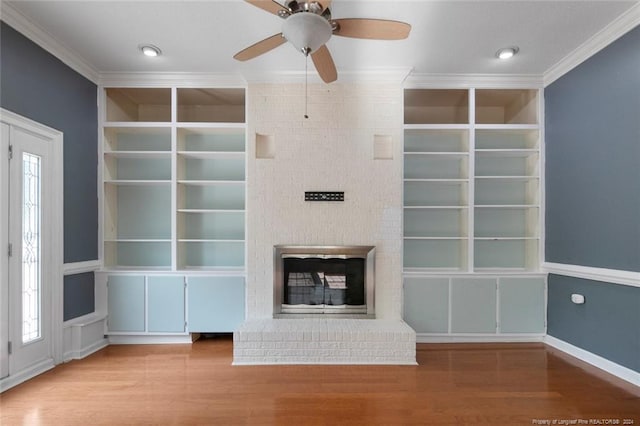 unfurnished living room with ceiling fan, light wood-type flooring, crown molding, and a brick fireplace