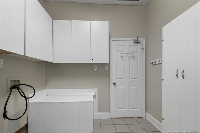 clothes washing area featuring cabinets, light tile patterned floors, and hookup for a washing machine