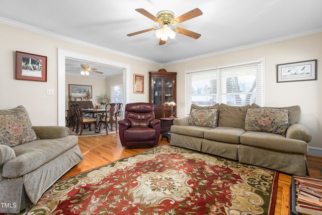 living room featuring crown molding, ceiling fan, and wood-type flooring