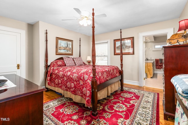 bedroom with ensuite bath, ceiling fan, and hardwood / wood-style floors