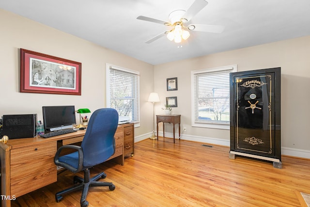 home office with light wood-type flooring and ceiling fan