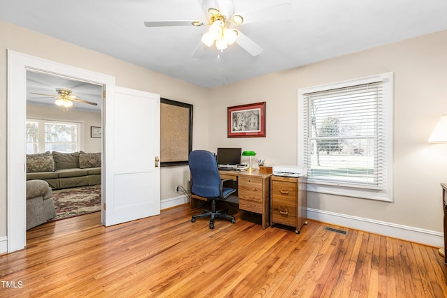 office space featuring a wealth of natural light, light hardwood / wood-style flooring, and ceiling fan