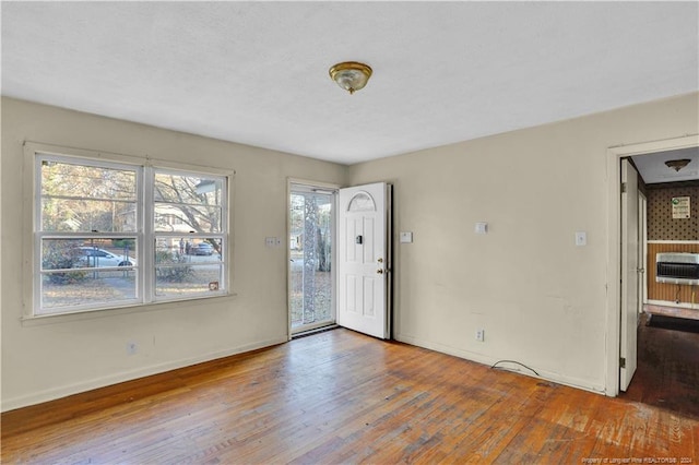 unfurnished room featuring hardwood / wood-style flooring and heating unit