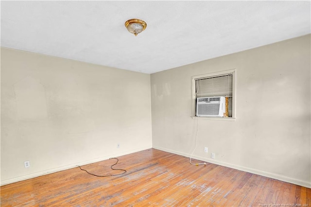 empty room with cooling unit and light wood-type flooring