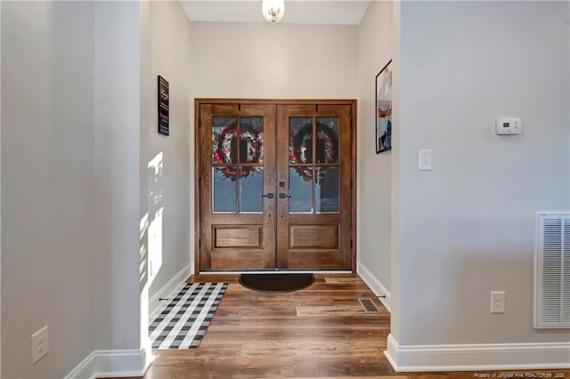 foyer featuring french doors, wood finished floors, visible vents, and baseboards