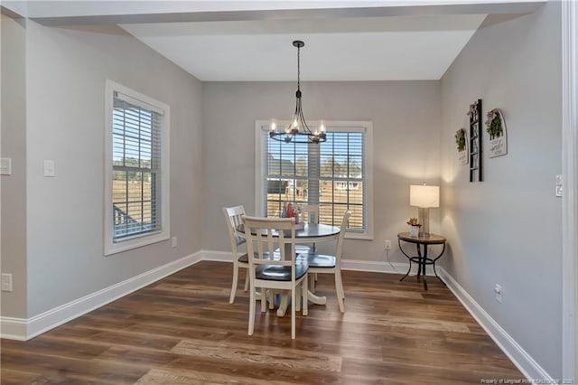 dining area featuring a chandelier, dark wood-type flooring, baseboards, and a healthy amount of sunlight