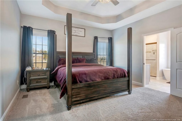 bedroom featuring carpet, multiple windows, and a raised ceiling