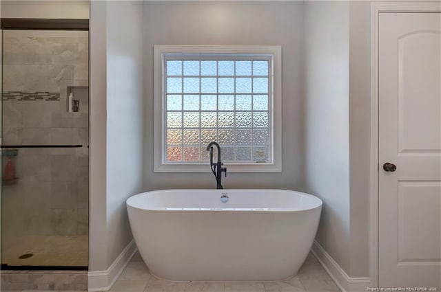 full bathroom featuring a soaking tub, tile patterned flooring, baseboards, and a stall shower