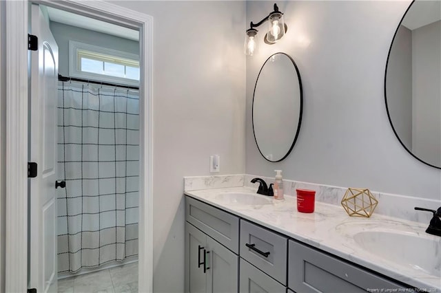 full bathroom with curtained shower, a sink, and double vanity