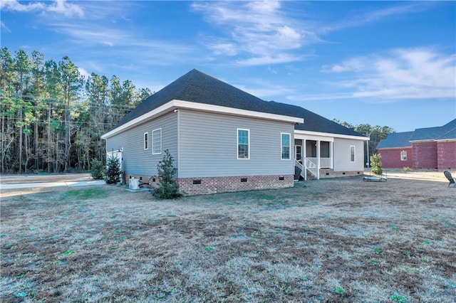 rear view of house featuring a yard and crawl space