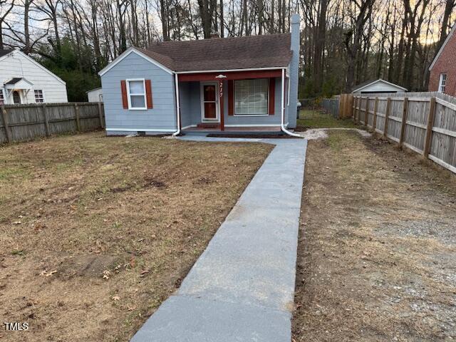 bungalow-style house featuring covered porch and a front yard