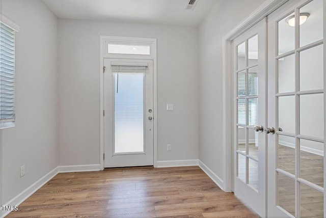 entryway featuring light wood-type flooring, french doors, and a healthy amount of sunlight