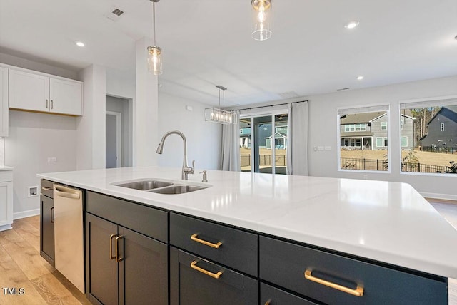 kitchen with pendant lighting, a center island with sink, light hardwood / wood-style floors, white cabinetry, and sink