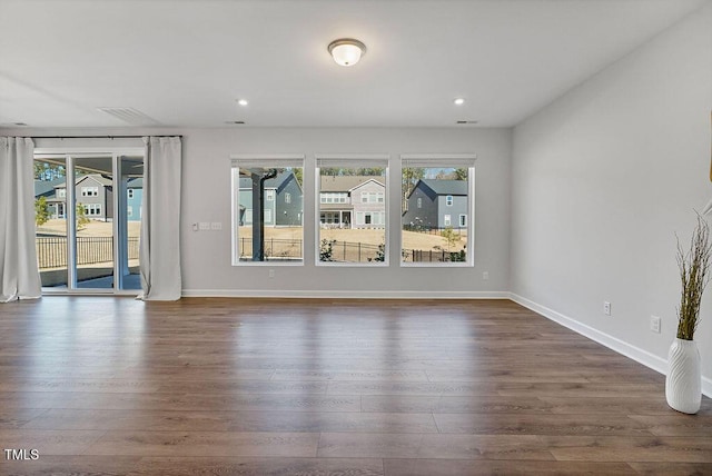 unfurnished living room with a healthy amount of sunlight and dark hardwood / wood-style floors