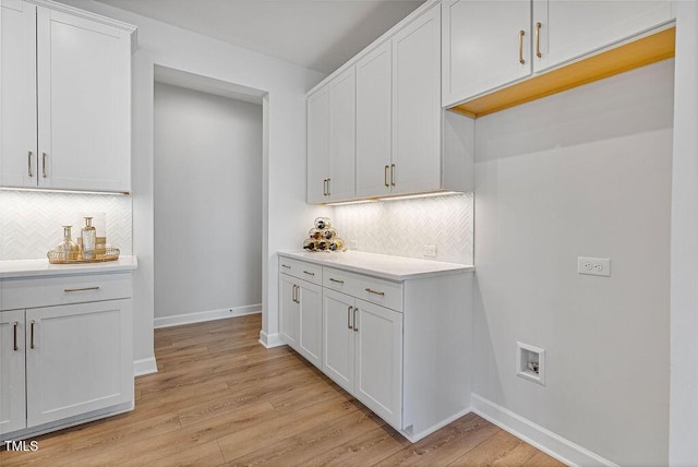 kitchen with white cabinetry, light hardwood / wood-style flooring, and decorative backsplash