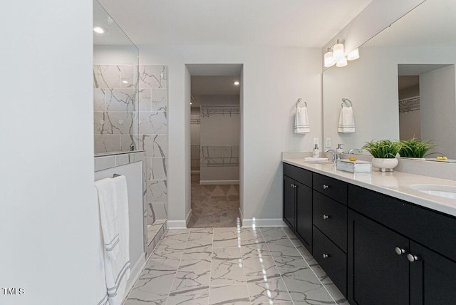 bathroom with tiled shower and vanity