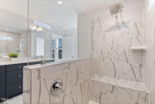 bathroom featuring a tile shower and vanity