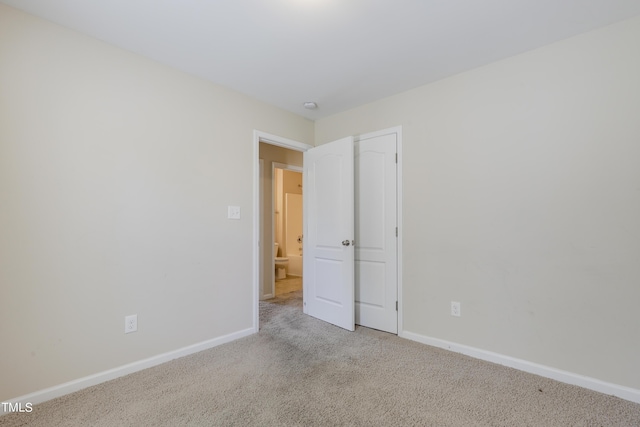 unfurnished room featuring light colored carpet