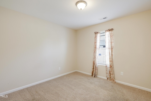 spare room featuring light colored carpet