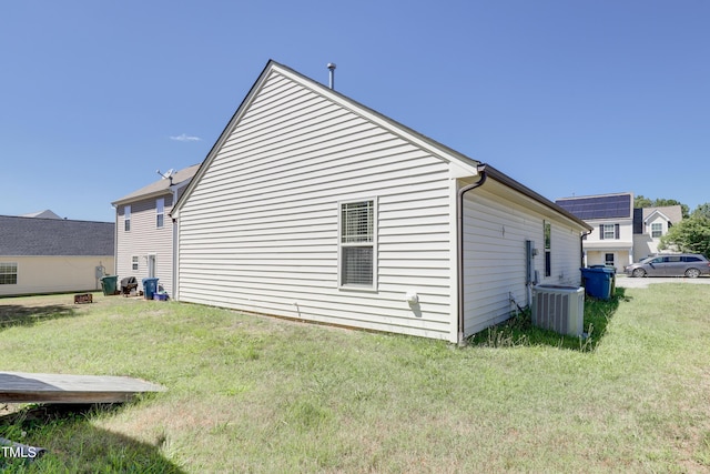 view of side of property featuring a lawn and central air condition unit